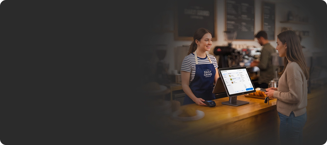 A barista handing a phone back to a customer at a café counter